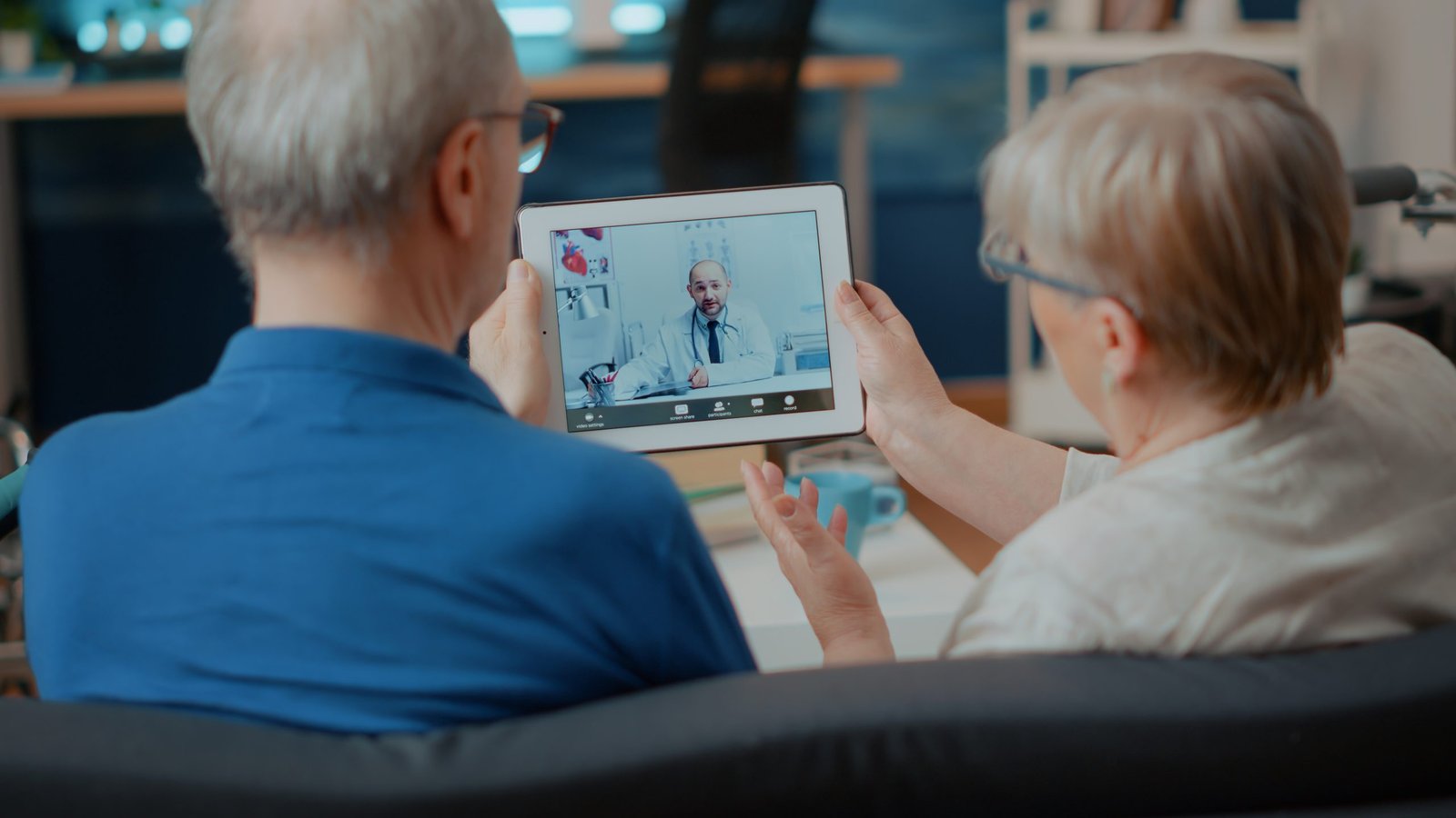 Improve Revenue - How Telehealth Can Help 15 Senior Couple Attending Online Meeting With Doctor Digital Tablet Doing Remote Consultation Home Elder People Using Videoconference Call Modern Gadget Internet Telemedicine Scaled 1